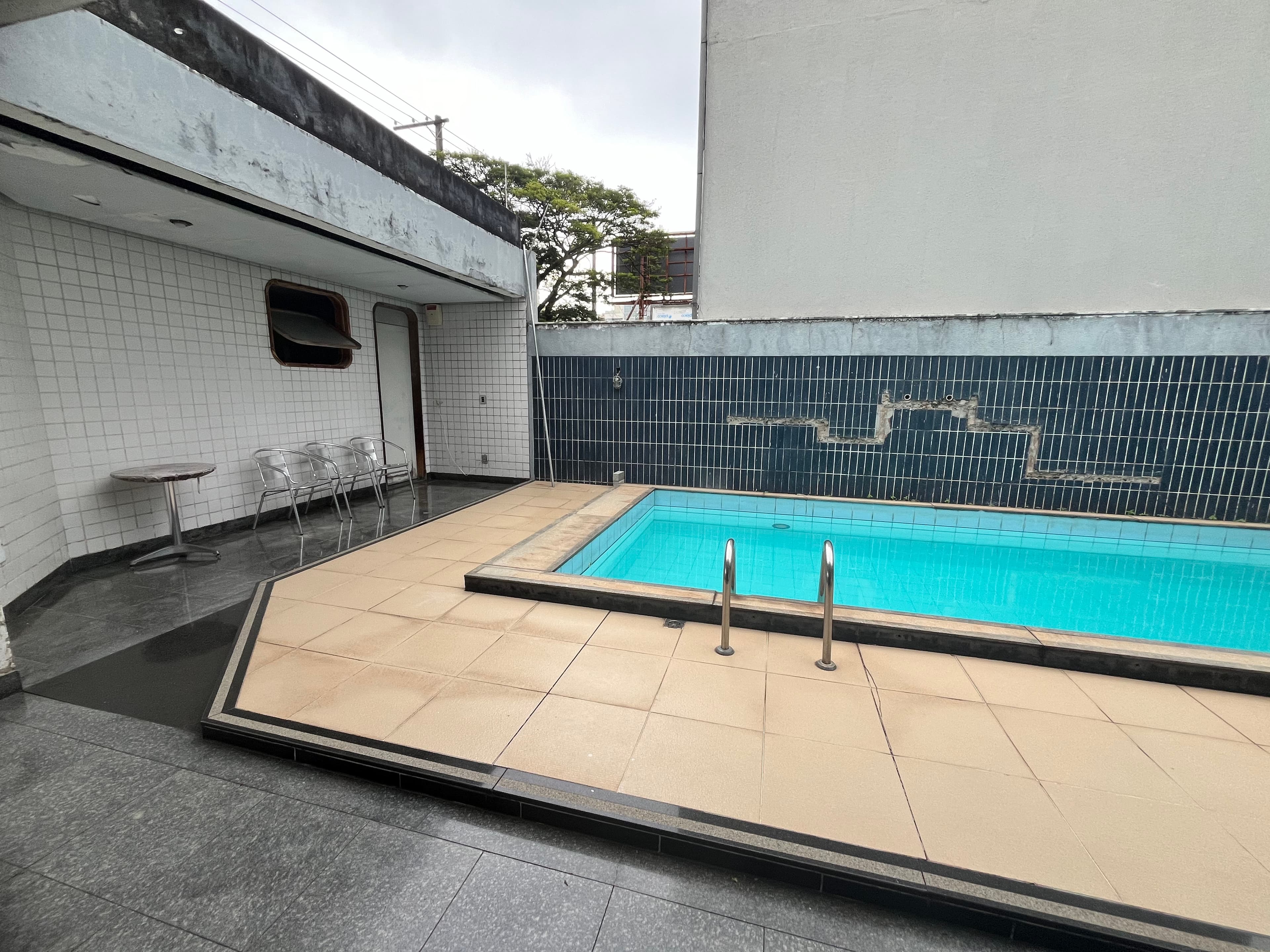 Área da piscina com espaço para mesas