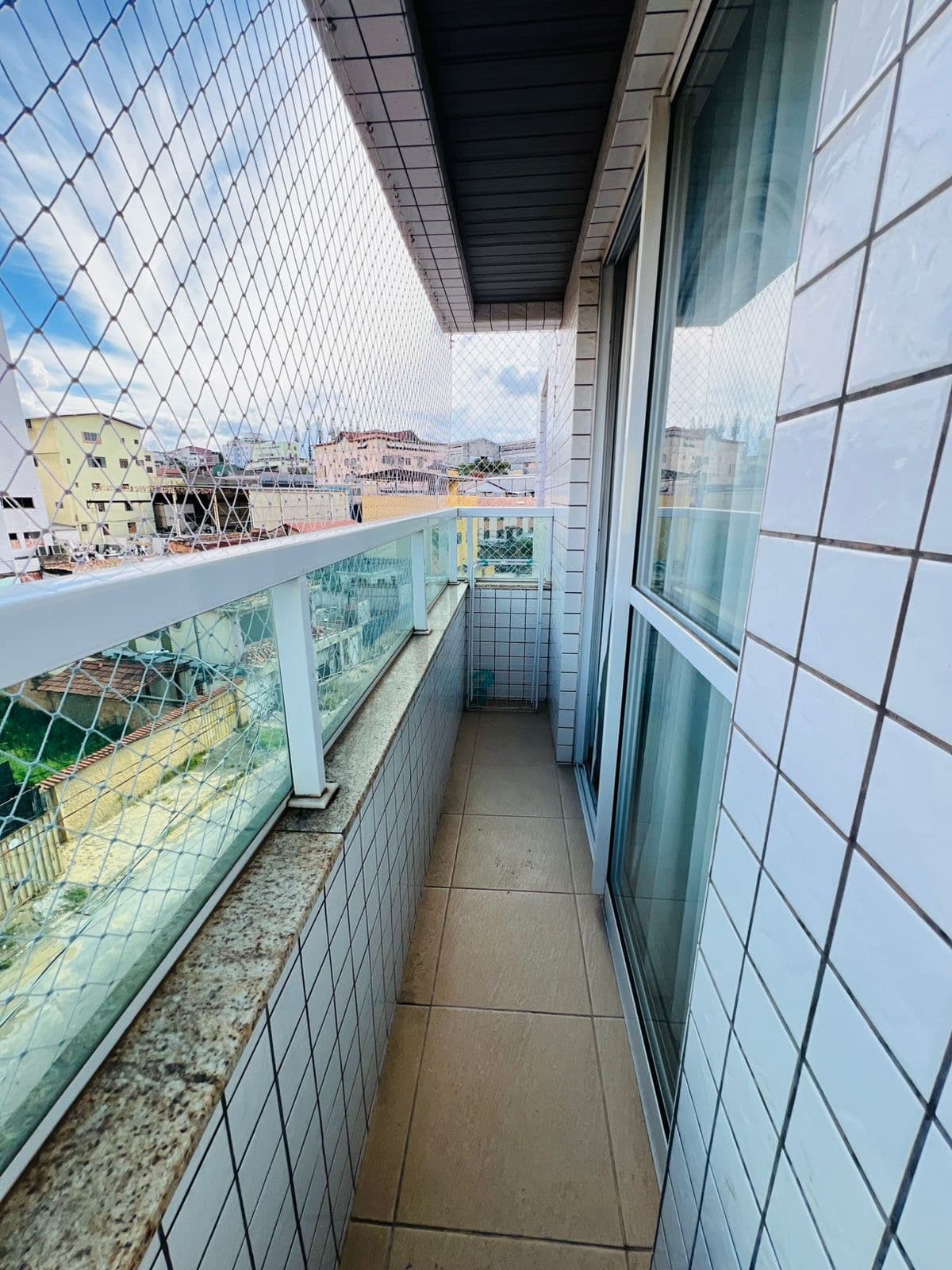 Varanda envidraçada com vista para os prédios vizinhos