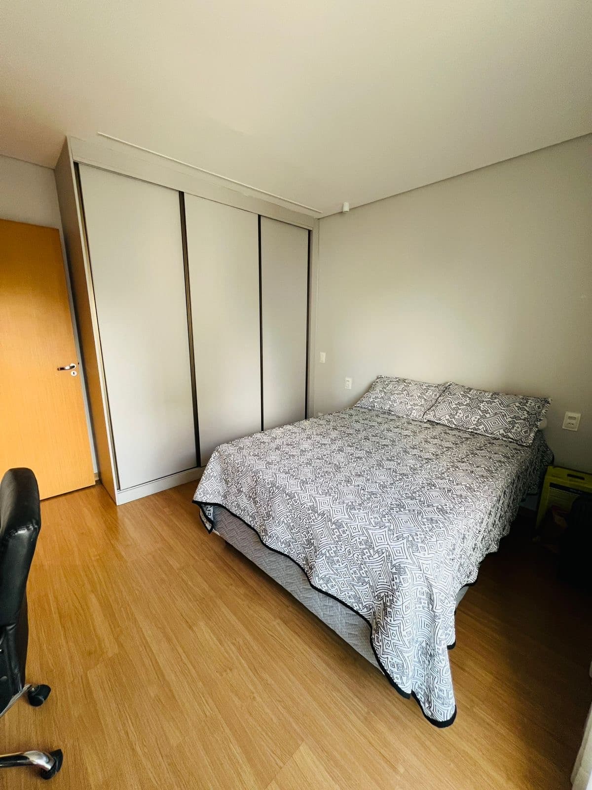 Segundo dormitório com cadeira de escritório e cama de casal