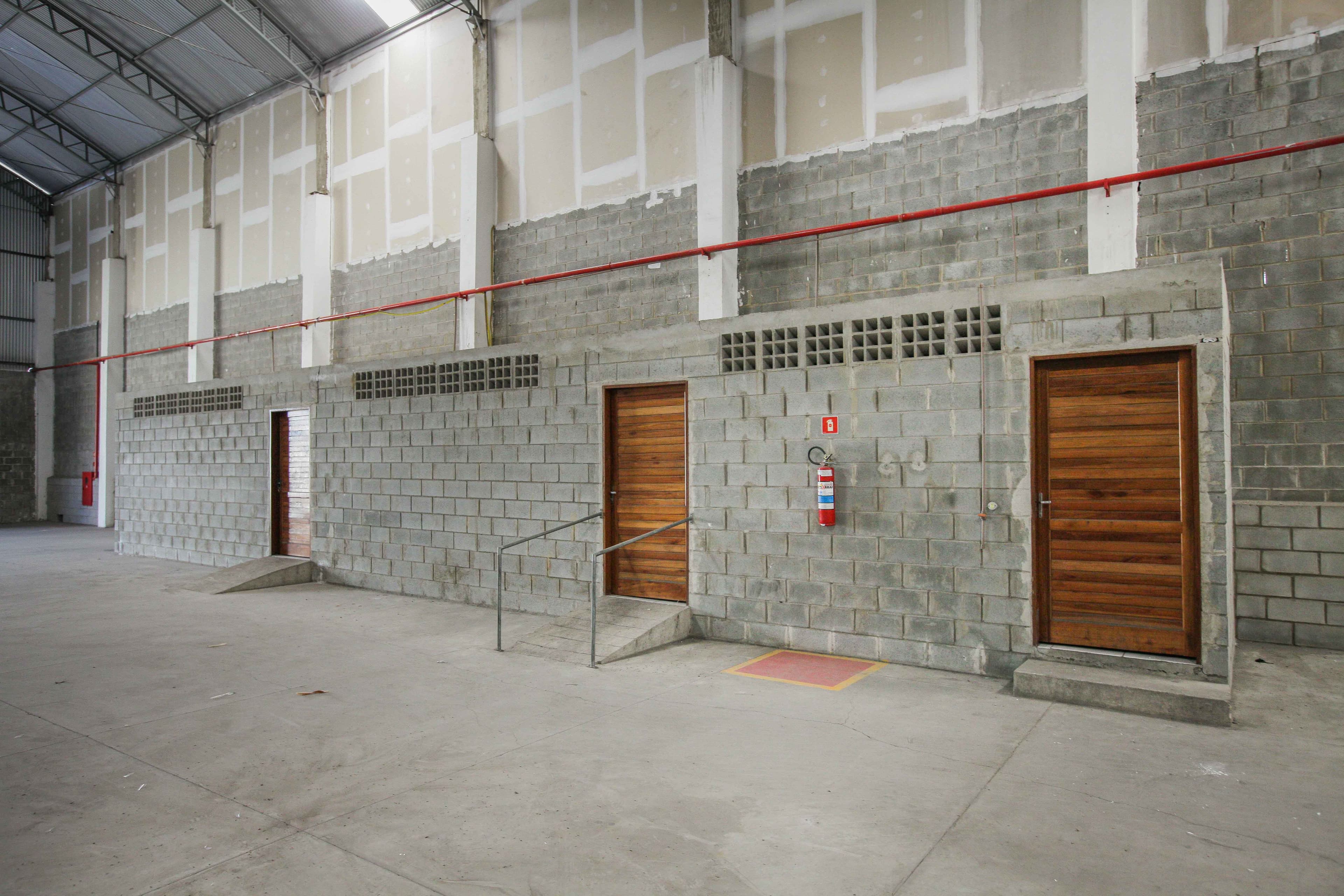 Área de apoio com duas portas de madeira e rampa de acesso com corrimão